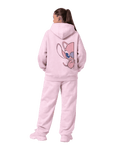 Person wearing a pink hoodie and pants with a cartoon character on the back, on a Pink background